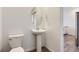 Stylish powder room with a pedestal sink, modern fixtures, and an adjacent hall at 6579 Parterre N Pkwy # 2, Thornton, CO 80602