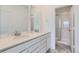 Modern bathroom featuring double sinks, quartz countertops, and a glass-enclosed shower at 6579 Parterre N Pkwy # 2, Thornton, CO 80602