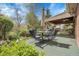 Back patio featuring outdoor dining table set with well-maintained landscaping at 6832 S Birch Way, Centennial, CO 80122
