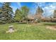 Large, lush backyard with mature trees and well-maintained lawn, providing a private oasis at 6832 S Birch Way, Centennial, CO 80122