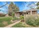 Charming backyard with a covered patio, garden beds, and a walkway, ideal for relaxation at 6832 S Birch Way, Centennial, CO 80122