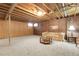 Spacious finished basement featuring exposed ceiling, carpeted floor and brick accent wall at 6832 S Birch Way, Centennial, CO 80122