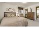 Cozy bedroom featuring a bed with beige bedding, two windows, and a wooden dresser at 6832 S Birch Way, Centennial, CO 80122