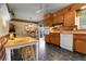 Charming eat-in kitchen featuring wood cabinetry, brick backsplash, and unique tile floors at 6832 S Birch Way, Centennial, CO 80122