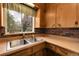 Kitchen area featuring double sinks, brick backsplash and wood cabinets at 6832 S Birch Way, Centennial, CO 80122