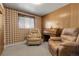 Cozy living room featuring wood paneling, carpeting, and natural light from a window at 6832 S Birch Way, Centennial, CO 80122