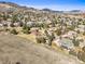 Expansive aerial view showcases a neighborhood nestled amongst rolling hills and lush green trees at 4 Prairie Falcon Ln, Littleton, CO 80127