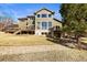 Back view of house showing deck, patio area, large yard and mature trees at 4 Prairie Falcon Ln, Littleton, CO 80127