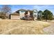 Back view of house showing deck, patio area, large yard and mature trees at 4 Prairie Falcon Ln, Littleton, CO 80127