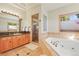 Bright bathroom featuring a walk-in shower, soaking tub with tile surround, and wood vanity at 4 Prairie Falcon Ln, Littleton, CO 80127