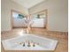 Close up of soaking tub with gold fixtures and beautiful window views in a bright bathroom at 4 Prairie Falcon Ln, Littleton, CO 80127