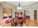 An interior shot of a dining room with hardwood floors, a wood table, and a view into the kitchen area at 4 Prairie Falcon Ln, Littleton, CO 80127