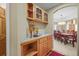 A hallway with glass door cabinets and countertops leads to the dining room with carpeted floors and a chandelier at 4 Prairie Falcon Ln, Littleton, CO 80127