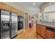 A kitchen with stainless steel appliances, a wooden bar, and a glimpse into the hallway and staircase at 4 Prairie Falcon Ln, Littleton, CO 80127