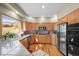 A kitchen with stainless steel appliances, tile countertops, wood cabinets, and a large window with a view at 4 Prairie Falcon Ln, Littleton, CO 80127