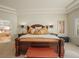 A carpeted primary bedroom featuring tray ceilings, dark wood furniture, and an ensuite bathroom at 4 Prairie Falcon Ln, Littleton, CO 80127