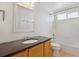 Bright bathroom featuring a stylish vanity with a dark countertop and a shower-tub combination at 4016 S Rome St, Aurora, CO 80018