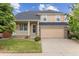 Charming two-story home with a well-manicured lawn, inviting porch, and a two car garage at 4016 S Rome St, Aurora, CO 80018