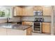 Kitchen featuring stainless steel appliances, light wood cabinets, and gray countertops at 4016 S Rome St, Aurora, CO 80018