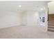 Spacious living room boasts neutral carpet, a staircase, and ample natural light from a window at 4016 S Rome St, Aurora, CO 80018
