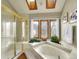 Luxurious bathroom featuring a soaking tub, a glass-enclosed shower, and large bright windows at 6505 S Garfield Ct, Centennial, CO 80121
