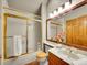 Traditional bathroom featuring vanity, shower with gold trim, and white tile at 6505 S Garfield Ct, Centennial, CO 80121