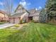 Charming front exterior featuring a brick facade, lush green lawn and mature landscaping at 6505 S Garfield Ct, Centennial, CO 80121