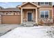 Front entrance of a two-story house with stone accents and a gray door at 11590 River Oaks Ln, Commerce City, CO 80640