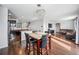 Open kitchen with dark cabinets, island, and dining area at 11590 River Oaks Ln, Commerce City, CO 80640