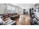 Open living space with hardwood floors, sectional sofa, and kitchen view at 11590 River Oaks Ln, Commerce City, CO 80640