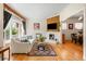 Bright living room with a brick fireplace, hardwood floors, and large windows at 2944 Hooker St, Denver, CO 80211