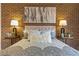 Bedroom features a brick wall accent and a comfortable bed with stylish bedding and matching side tables with lamps at 999 N Emerson St # 10, Denver, CO 80218