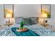 Luxurious bedroom highlights a comfortable bed with plush pillows, enhanced by decorative lamps and stylish decor at 999 N Emerson St # 10, Denver, CO 80218