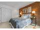 Cozy bedroom featuring a brick wall, soft lighting, and patterned bedding with white closet doors at 999 N Emerson St # 10, Denver, CO 80218