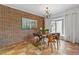 Charming dining room featuring a brick wall, stylish chandelier, and a modern wooden table with four chairs at 999 N Emerson St # 10, Denver, CO 80218