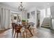 Open dining area boasts a decorative chandelier, bay window, and seamless transition to stairs with updated fixtures at 999 N Emerson St # 10, Denver, CO 80218