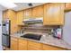 Functional kitchen with laminate countertops, oak cabinetry, and black appliances at 999 N Emerson St # 10, Denver, CO 80218