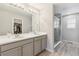 Well-lit bathroom showcasing a double sink vanity, large mirror, and a glass-enclosed shower at 2008 Makley Loop, Castle Rock, CO 80104