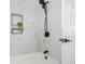 Modern bathroom with white marble-like tile, matte black hardware, and a tiled shelf niche at 6699 S Pennsylvania St, Centennial, CO 80121