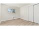 Minimal bedroom with clean white walls, a large window, a closet, and wood floors at 6699 S Pennsylvania St, Centennial, CO 80121