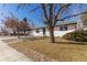 This single-story home features a white brick exterior and a well-kept lawn on a corner lot at 6699 S Pennsylvania St, Centennial, CO 80121
