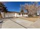 This single-story home features a white brick exterior, a front-facing garage, and a well-kept lawn at 6699 S Pennsylvania St, Centennial, CO 80121