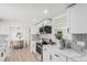 Bright kitchen featuring white cabinets, stainless steel appliances, and stylish backsplash with a dining area view at 6699 S Pennsylvania St, Centennial, CO 80121