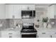 Modern kitchen featuring white cabinets, marble countertops, subway tile backsplash, and stainless steel appliances at 6699 S Pennsylvania St, Centennial, CO 80121
