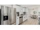 Modern kitchen with stainless steel appliances, white cabinets, mosaic backsplash, and an open view to the dining area at 6699 S Pennsylvania St, Centennial, CO 80121