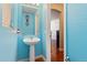 Bathroom with bright turquoise walls, pedestal sink, and modern fixtures at 5555 Perth Ct, Denver, CO 80249