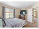 Cozy bedroom featuring a window view, dresser with TV, and a neutral color palette at 5555 Perth Ct, Denver, CO 80249