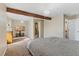 Spacious bedroom with decorative beam, carpet, and adjacent bathroom at 5555 Perth Ct, Denver, CO 80249
