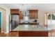 Modern kitchen featuring an island with seating, stainless steel appliances, and custom cabinetry at 5555 Perth Ct, Denver, CO 80249