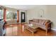 Inviting living room with gleaming hardwood floors, a comfortable sofa, and abundant natural light at 5555 Perth Ct, Denver, CO 80249